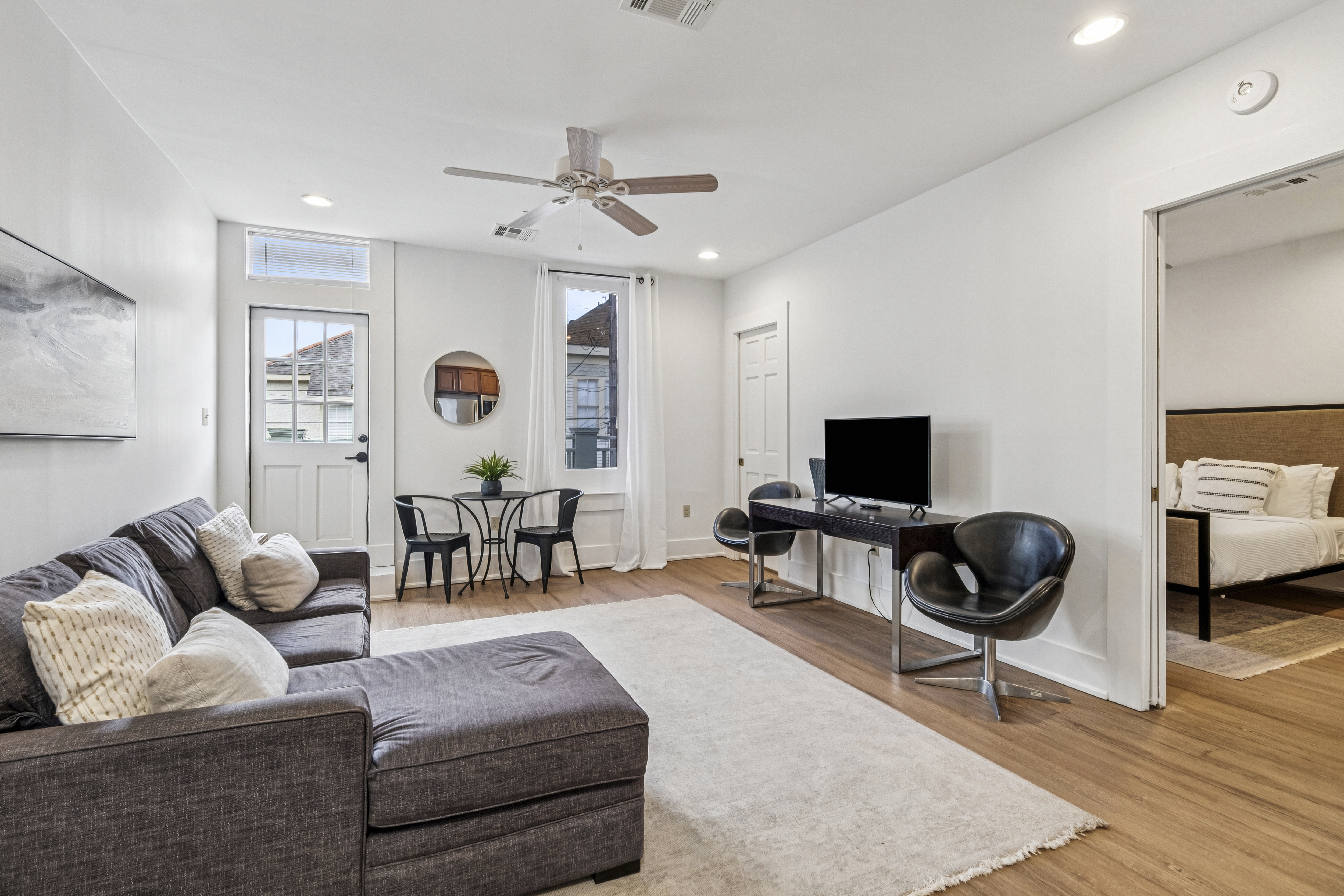 The One Bedroom at Unit 202, a bright living room with a sectional sofa and dining area