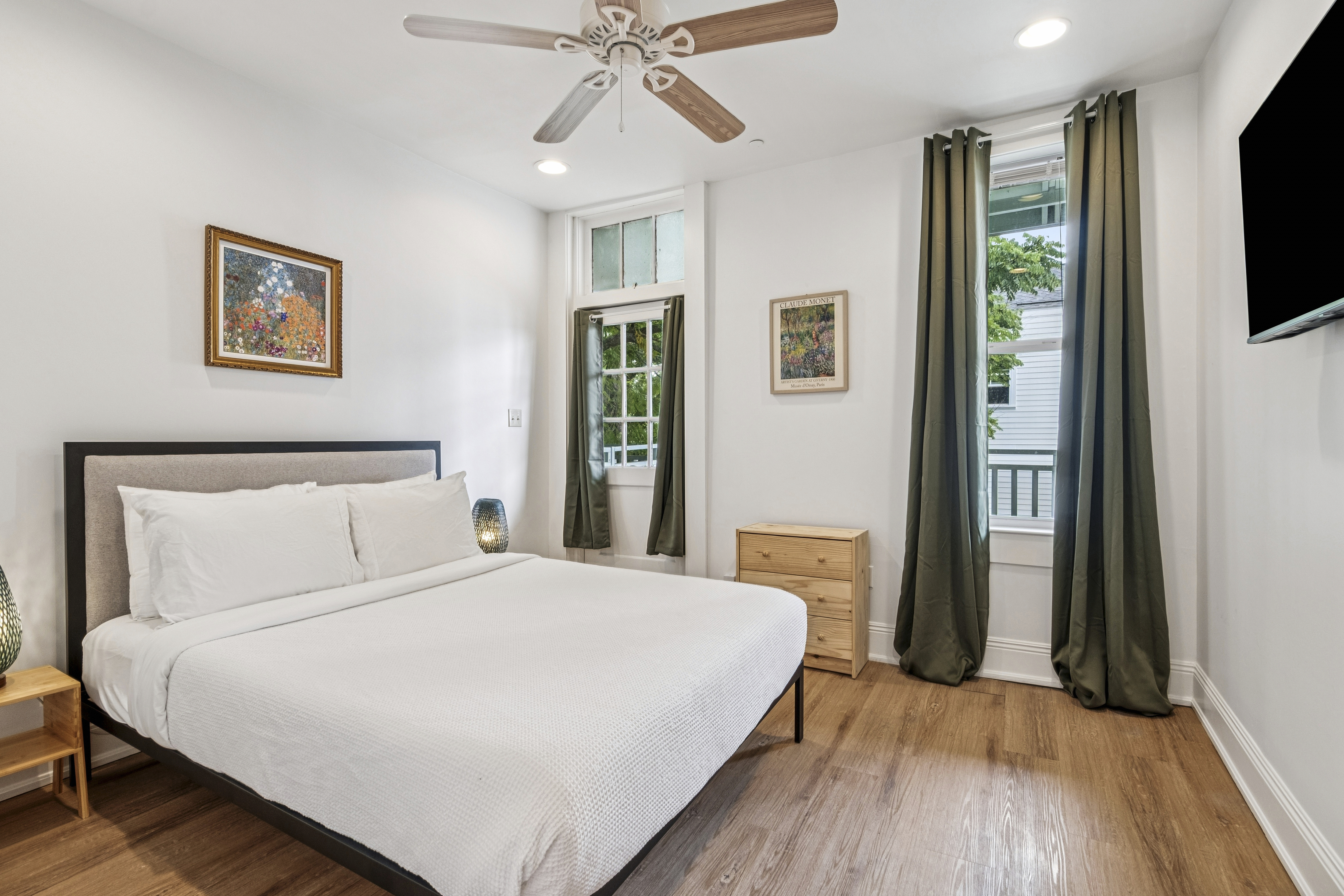 Unit 204 primary bedroom with king bed and green drapes