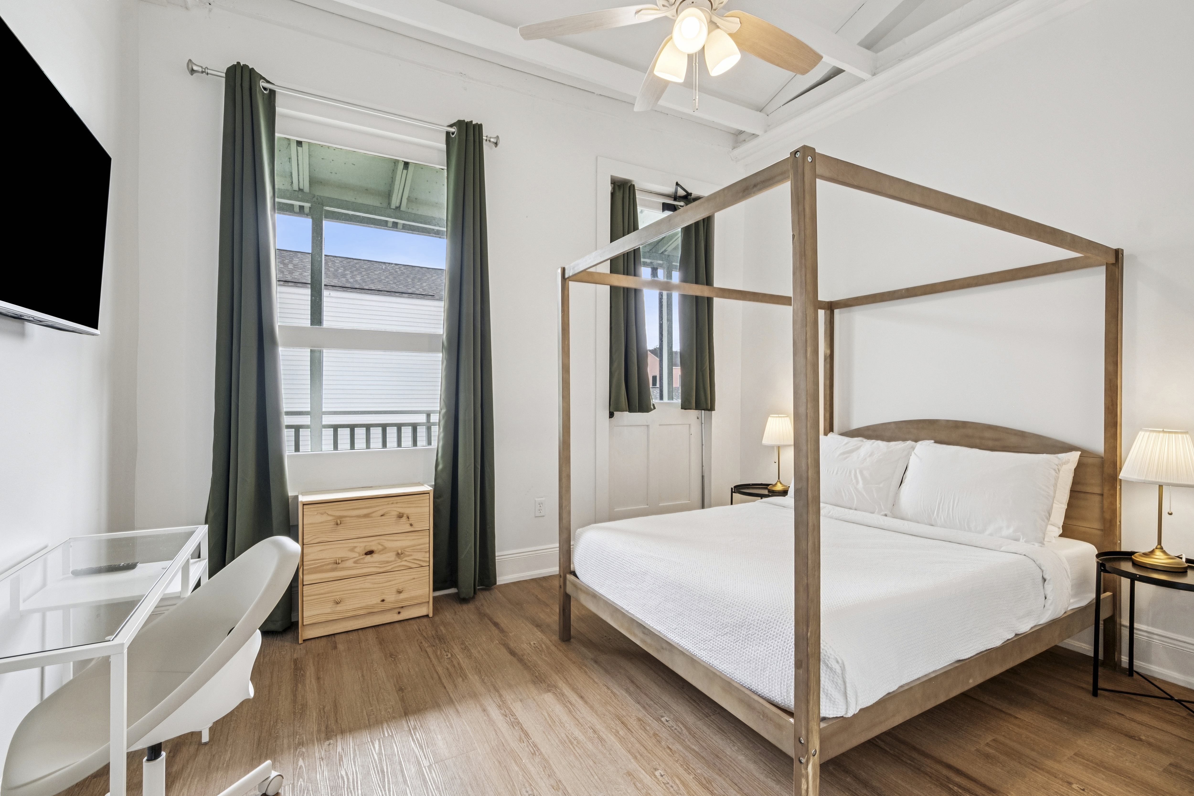 Unit 204 second bedroom with a four-poster frame and desk